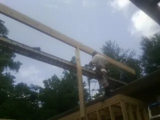 Carpenter setting a ridge beam over a new addition frame — Ice Dam Removal by Roofing Brothers in Gowen