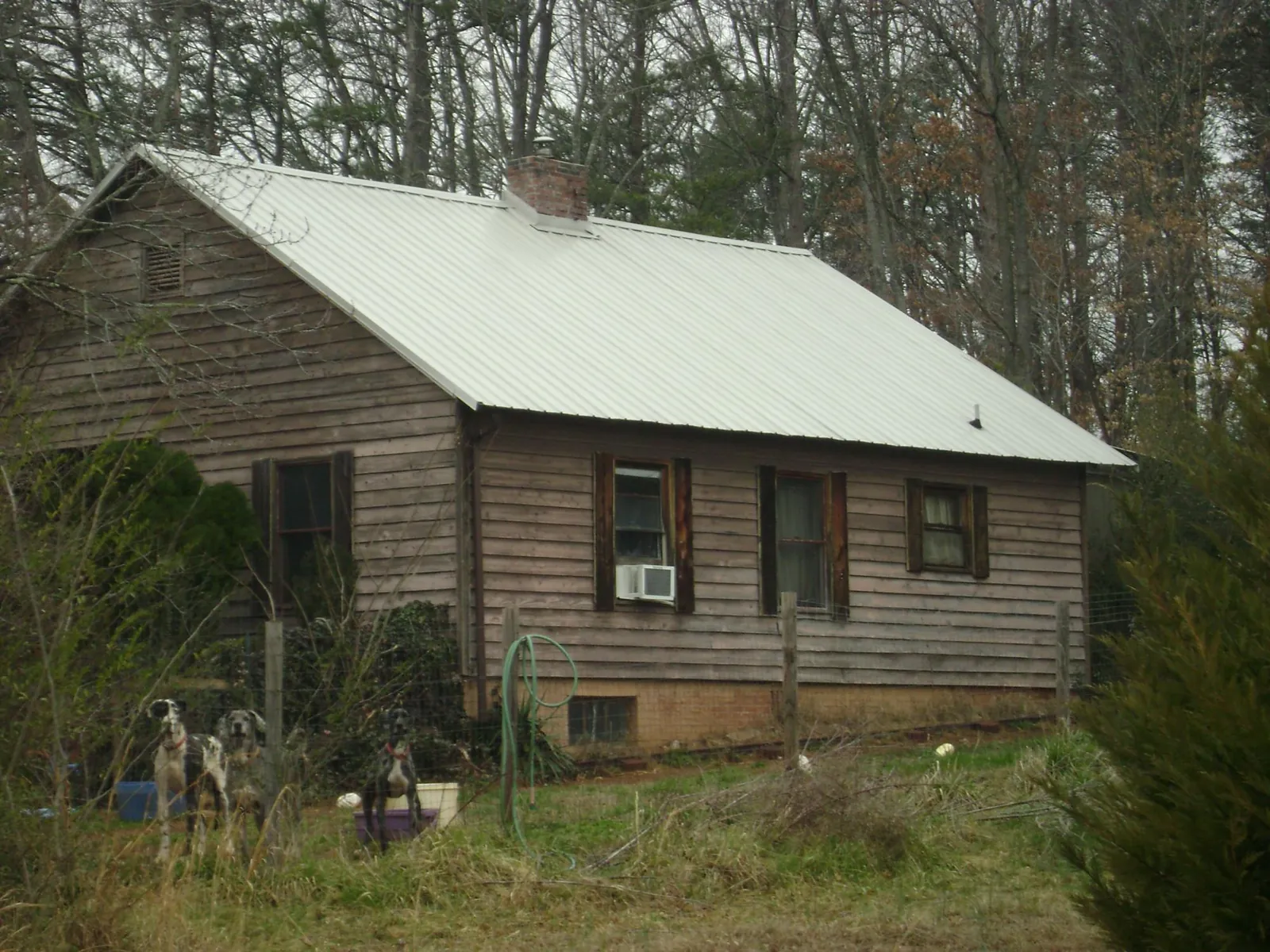White metal roof on an old wood sided farmhouse, from a Metal Roof Installation job in Gowen